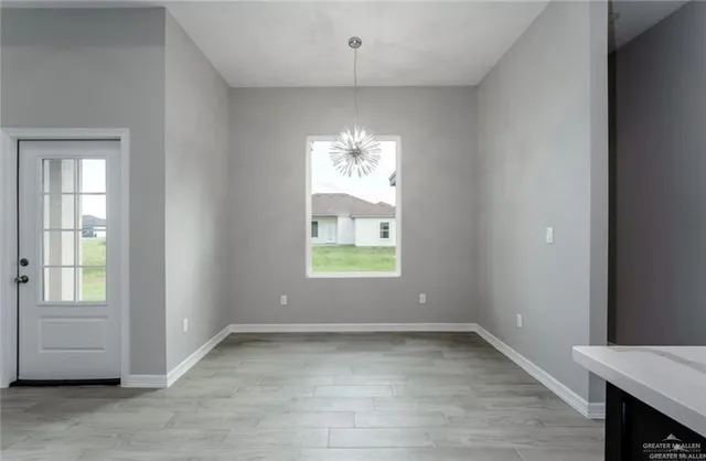 an empty room with windows and chandelier