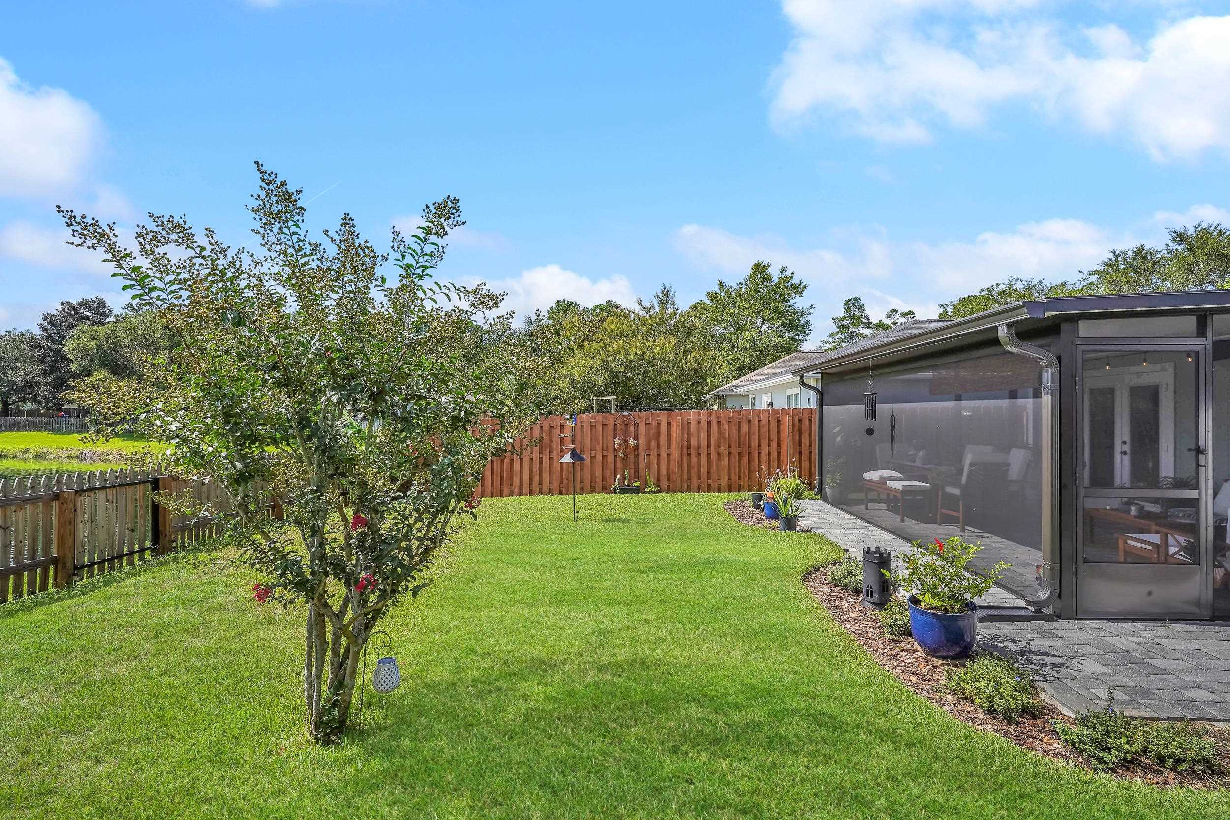 891 Wynfield Circle St. Augustine, FL 32092 - Photo 24 of 37 a backyard of a house with lots of green space and wooden fence