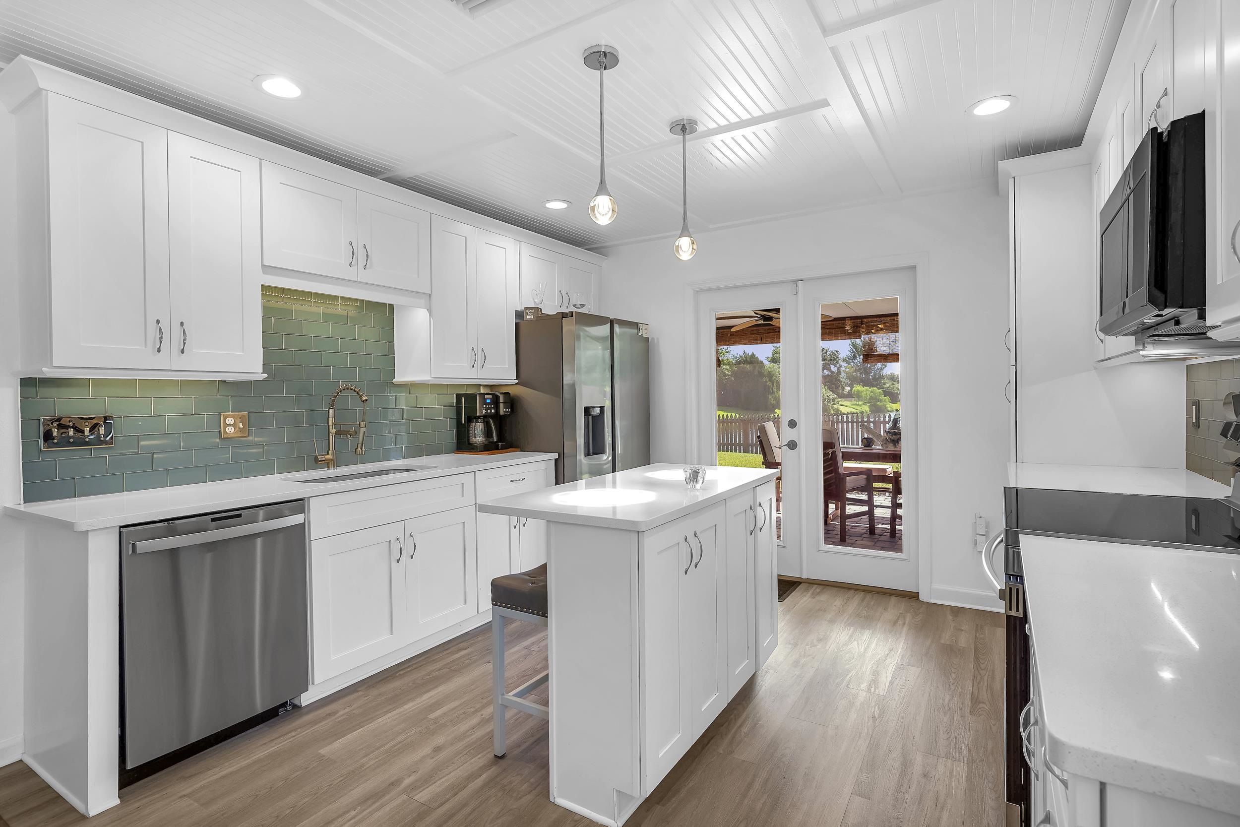 891 Wynfield Circle St. Augustine, FL 32092 - Photo 8 of 37 a kitchen with stainless steel appliances kitchen island granite countertop a stove a sink a refrigerator and white cabinets with wooden floor