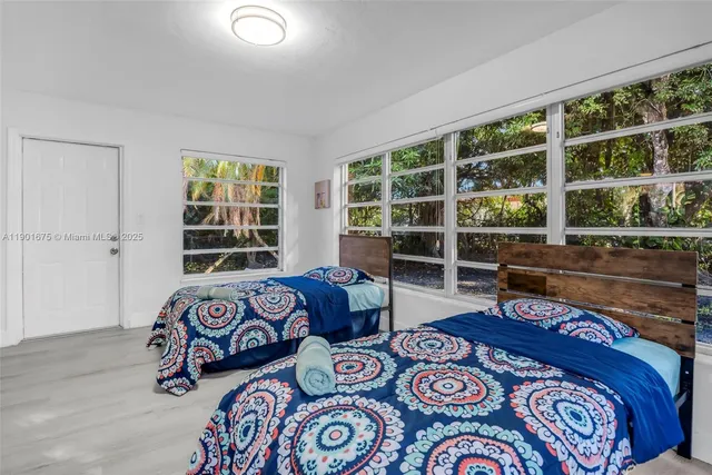 a bedroom with two beds and a window