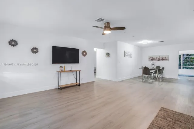 a view of a livingroom with a flat screen tv and a ceiling fan