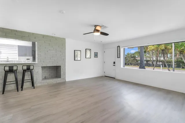 wooden floor fireplace and windows in an empty room