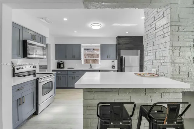 a kitchen with stainless steel appliances kitchen island granite countertop a sink and cabinets