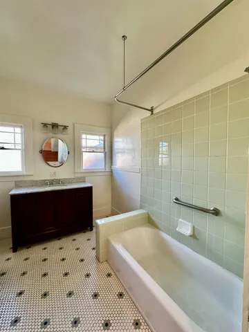 a bathroom with a sink toilet a mirror and bathtub