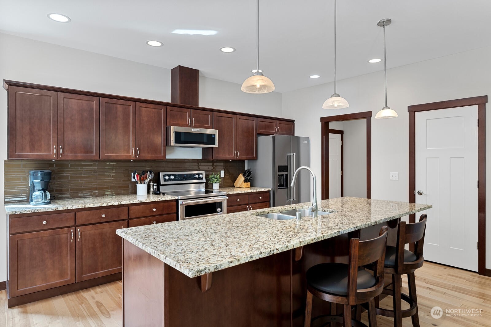 18610 Russian Road Arlington, WA 98223 - Photo 13 of 40 a kitchen with stainless steel appliances granite countertop a kitchen island hardwood floor sink stove dining table and chairs