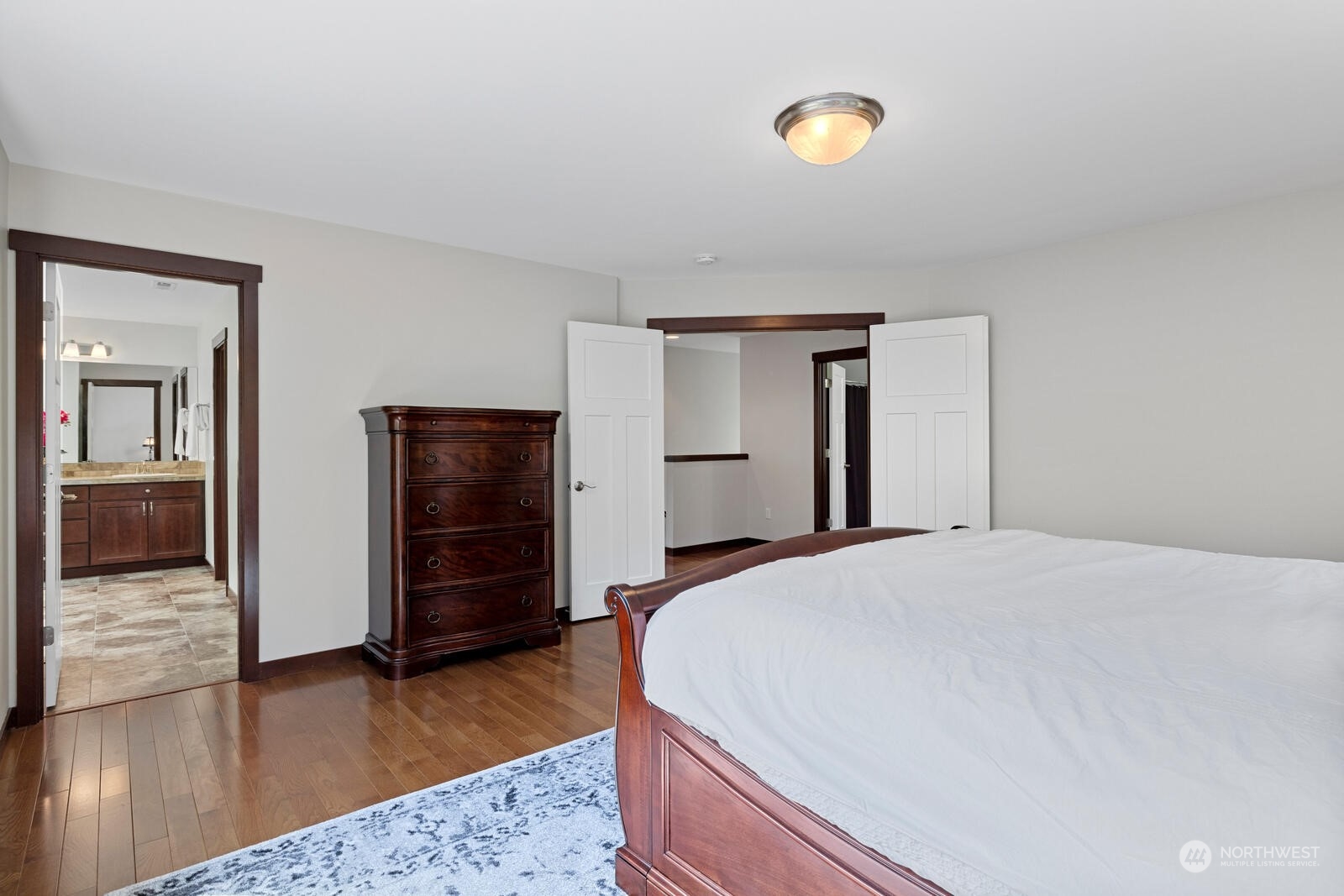 18610 Russian Road Arlington, WA 98223 - Photo 23 of 40 a spacious bedroom with a bed and wooden floor