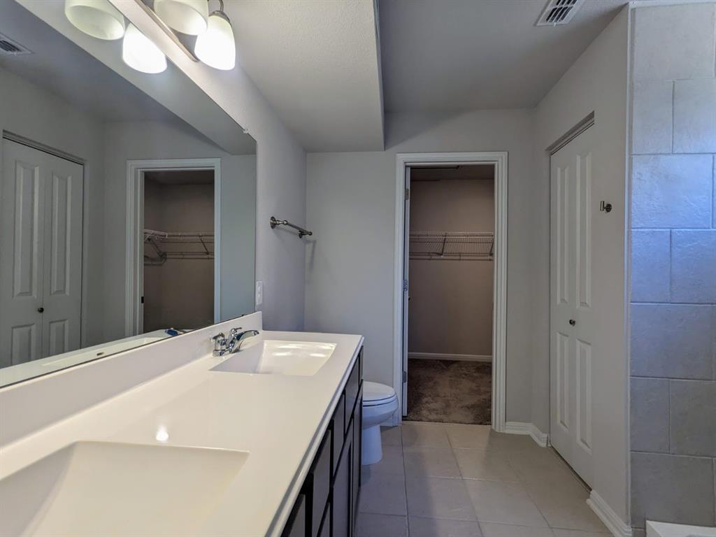 196 Martha Lane Kyle, TX 78640 - Photo 15 of 30 a bathroom with a sink a mirror and a shower