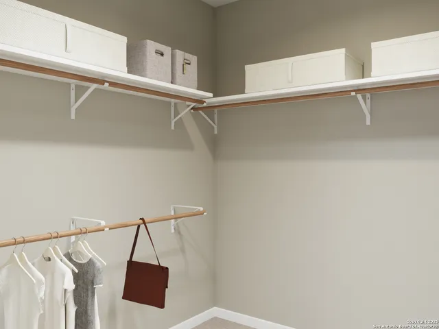 a view of walk in closet with clothes and shoes