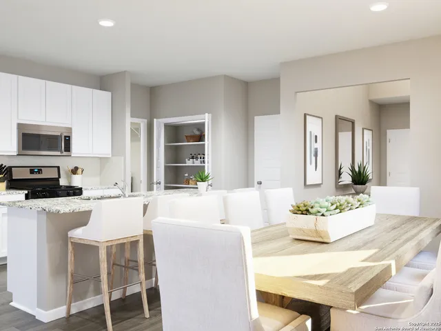 a living room with stainless steel appliances kitchen island granite countertop a dining table chairs and a refrigerator