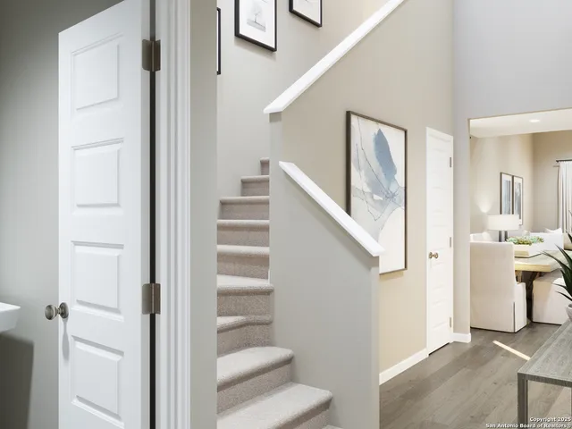 a white vase with flowers and a window