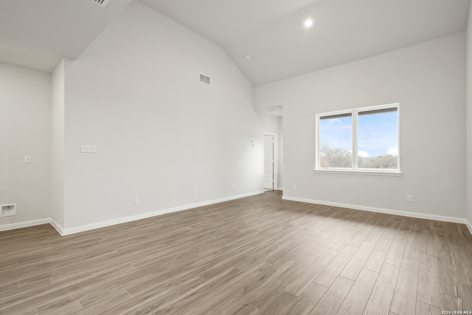 13631 Helton Pass St. Hedwig, TX 78152 - Photo 7 of 33 a view of an empty room with wooden floor and a window
