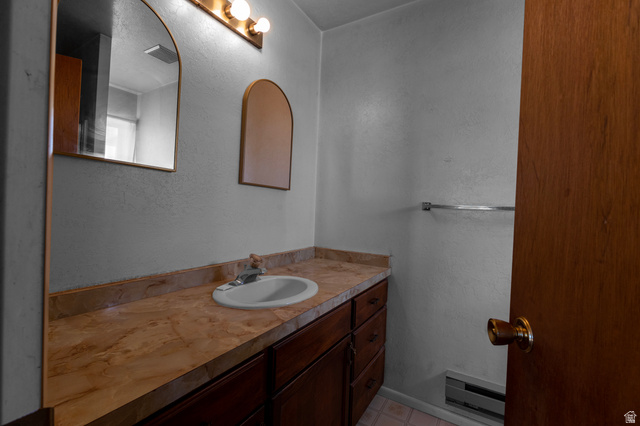 1208 East Tidwell Road Loa, UT 84747 - Photo 25 of 40 Half bathroom featuring a textured wall, vanity, and a baseboard radiator
