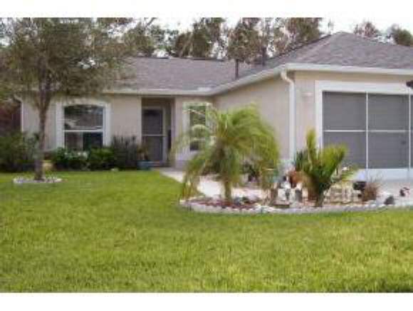 2126 Northeast Spring Creek Palm Bay, FL 32905 - Photo 1 of 1 a front view of a house with a yard
