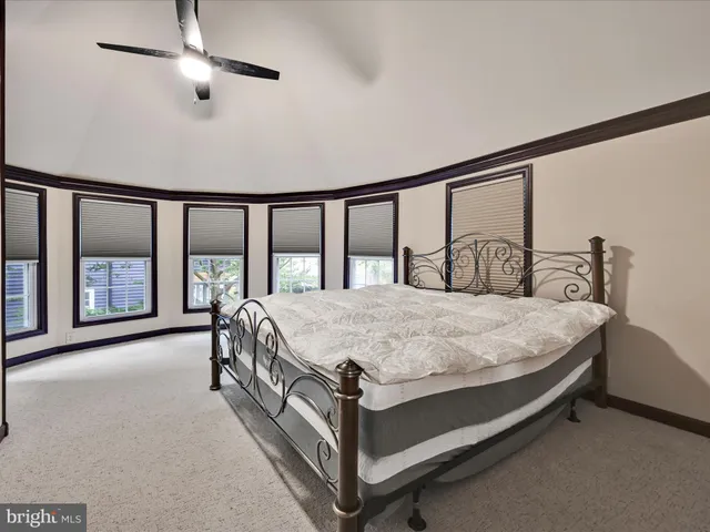 a bedroom with a bed lamp and a large window