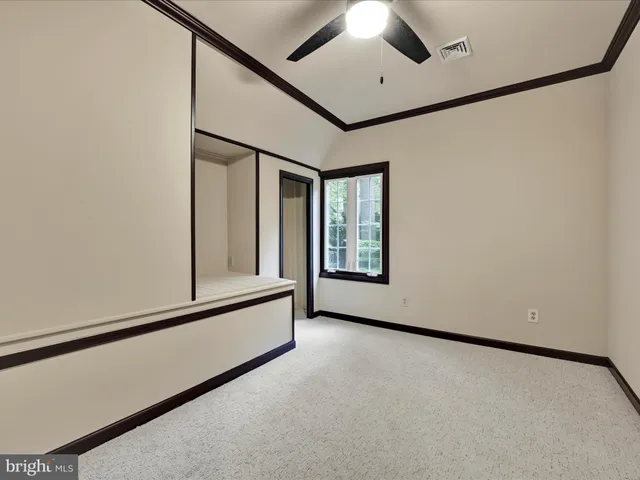 a view of a room with a hallway and a chandelier fan