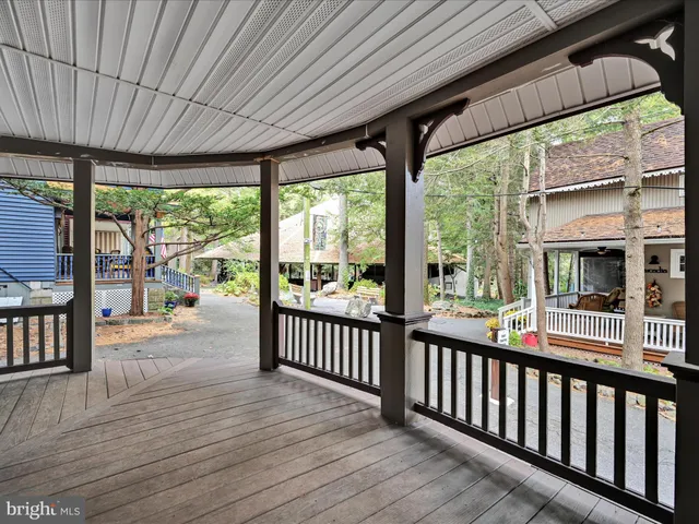 a view of a street with sitting area and bench under an umbrella