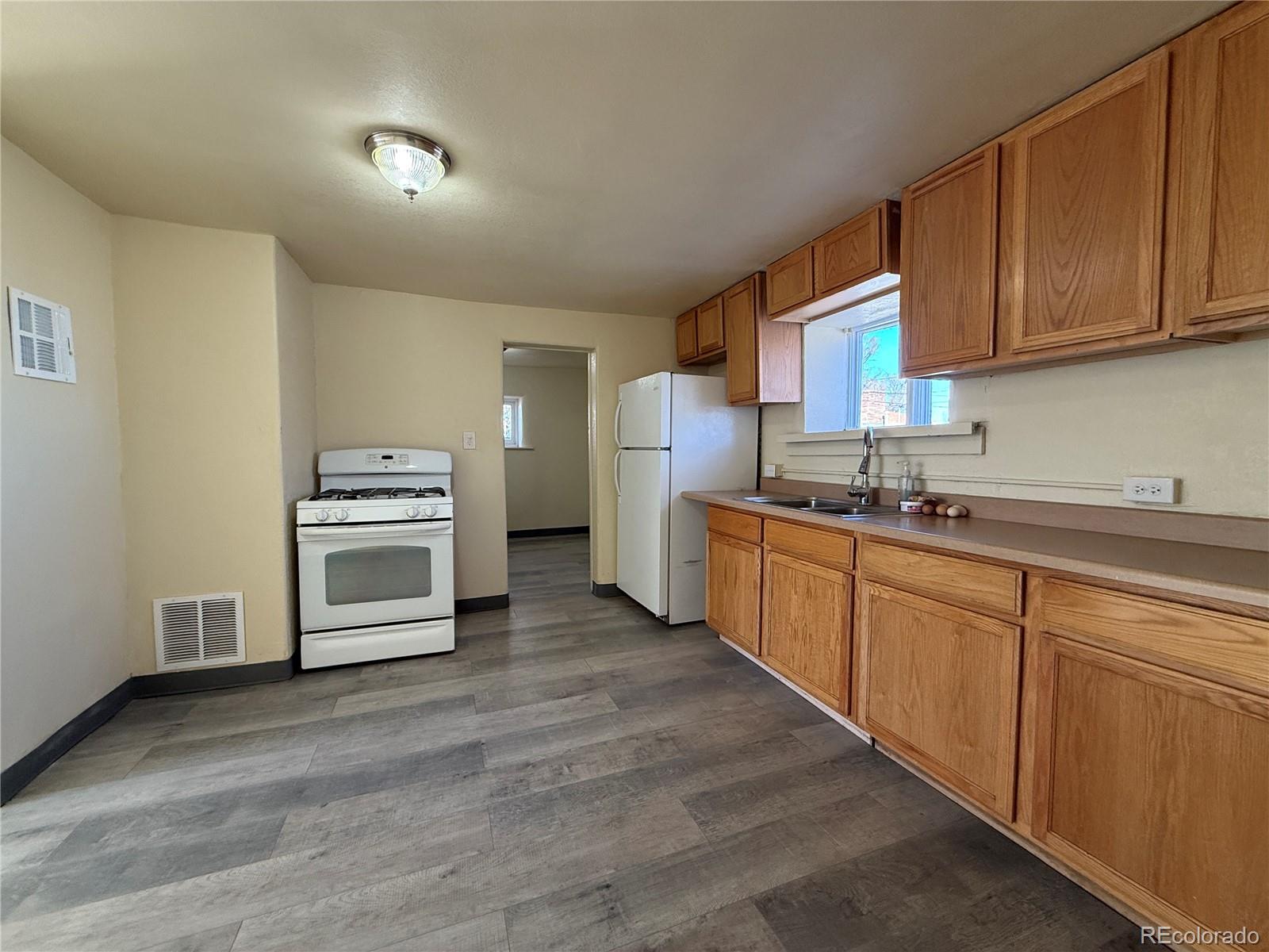 623 9th Street Alamosa, CO 81101 - Photo 3 of 10 a kitchen with stainless steel appliances granite countertop a stove a sink and a refrigerator