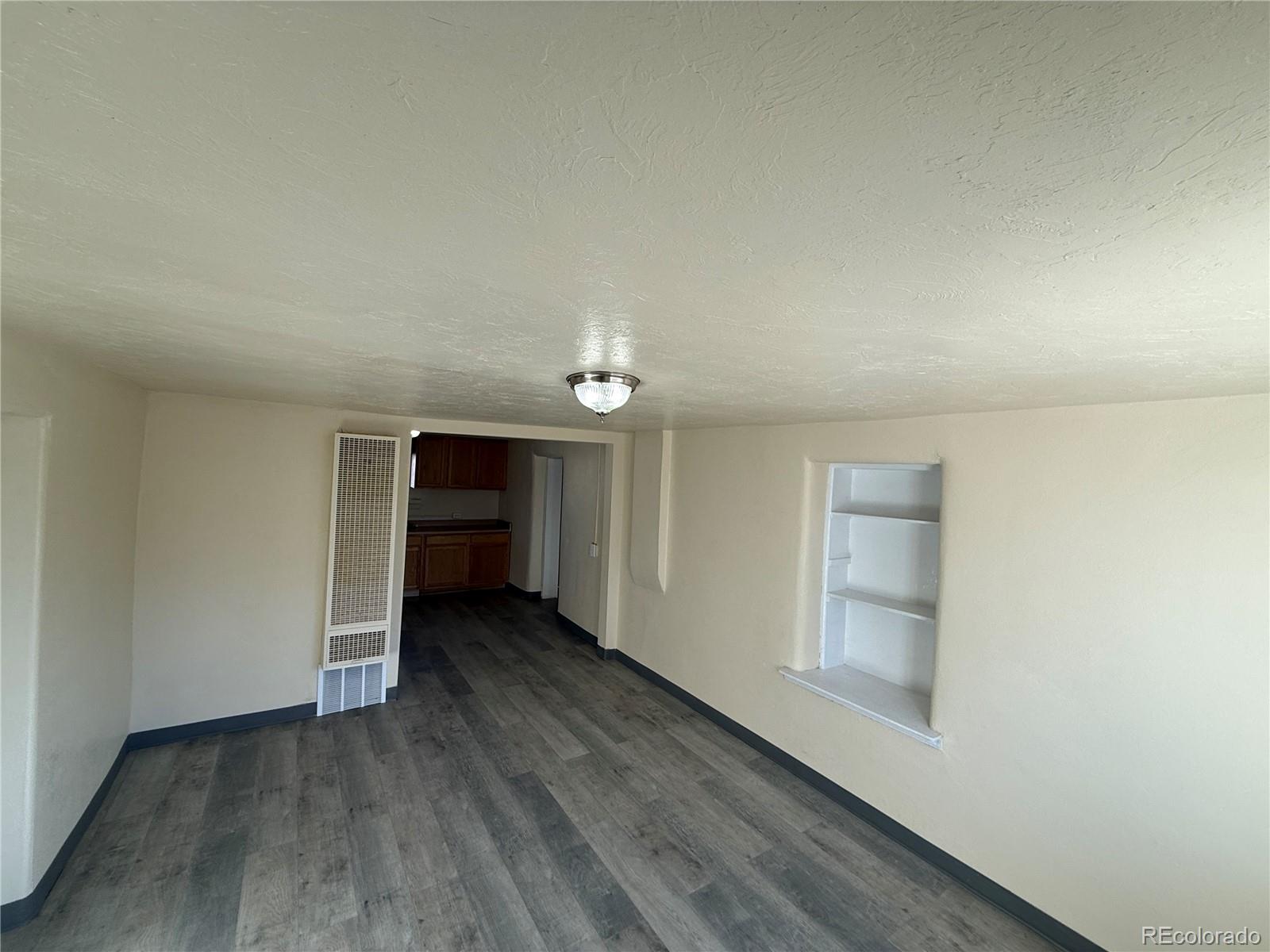 623 9th Street Alamosa, CO 81101 - Photo 7 of 10 an empty room with wooden floor closet and cabinet
