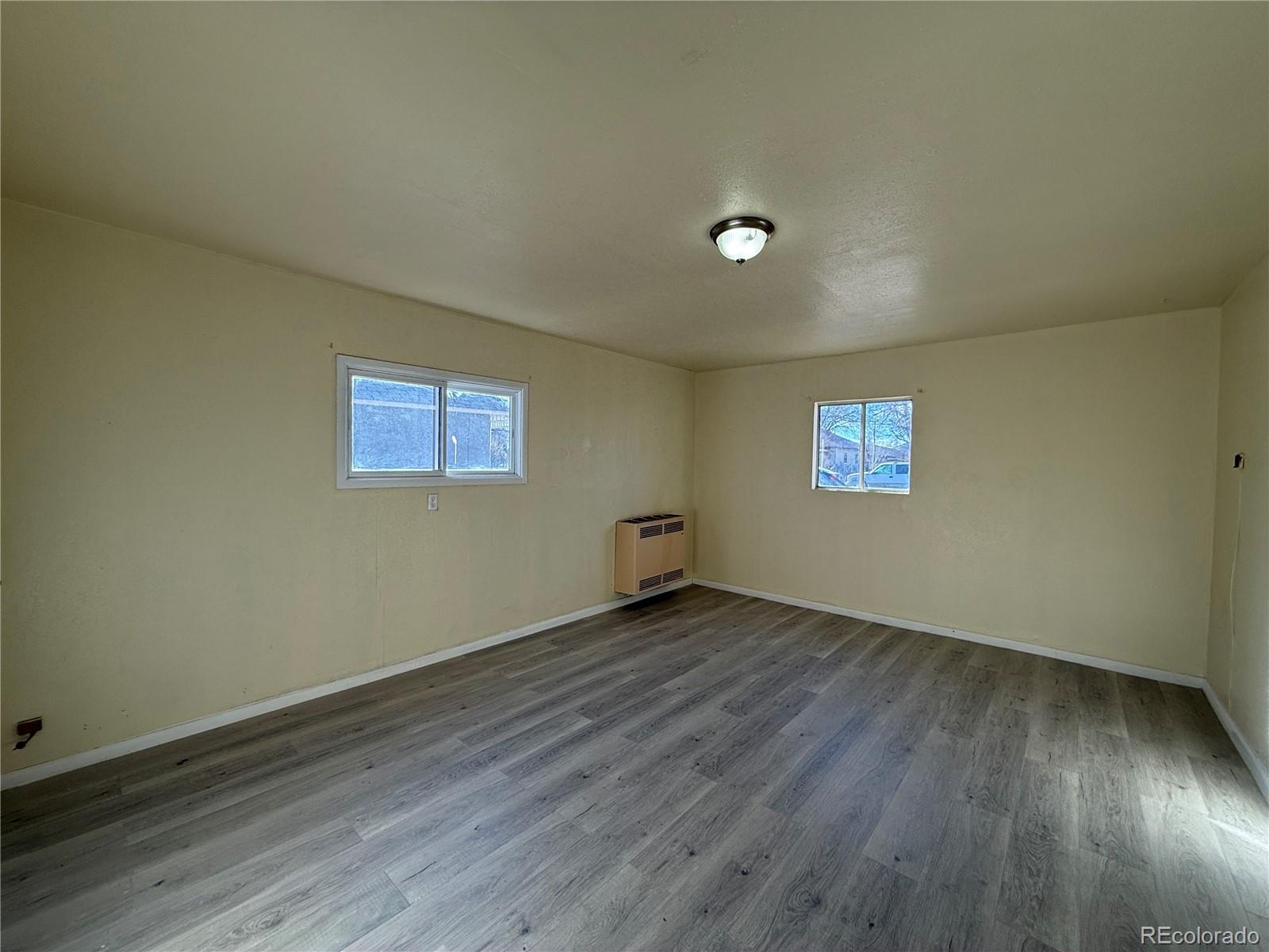 623 9th Street Alamosa, CO 81101 - Photo 8 of 10 a view of an empty room with wooden floor and a window