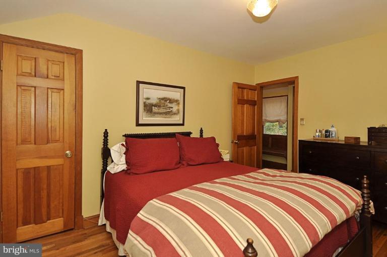 10003 Raynor Road Silver Spring, MD 20901 - Photo 16 of 28 a bedroom with a large bed and a chandelier
