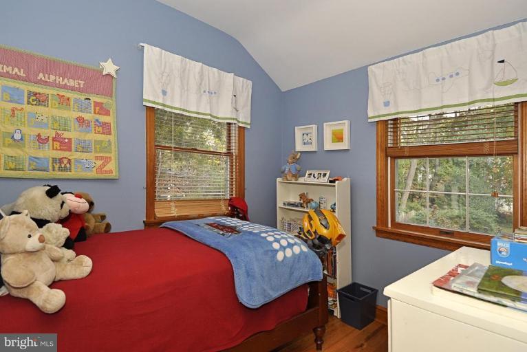 10003 Raynor Road Silver Spring, MD 20901 - Photo 19 of 28 a bedroom with a bed next to a window with a book shelf