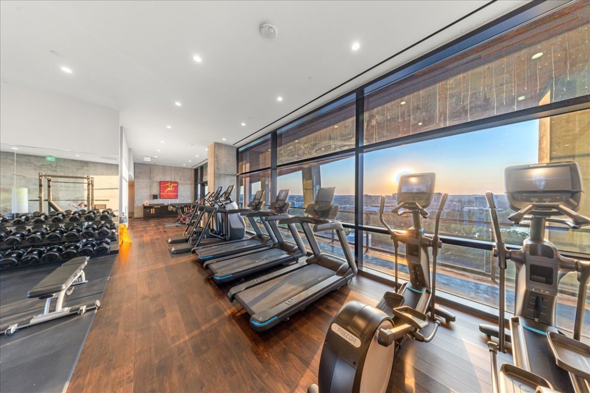 70 Rainey Street, Unit 1503 Austin, TX 78701 - Photo 22 of 30 Gym featuring a wall of windows, dark wood finished floors, and recessed lighting