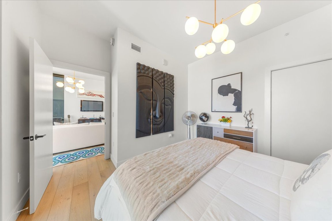 70 Rainey Street, Unit 1503 Austin, TX 78701 - Photo 10 of 30 Bedroom with a chandelier and light wood finished floors