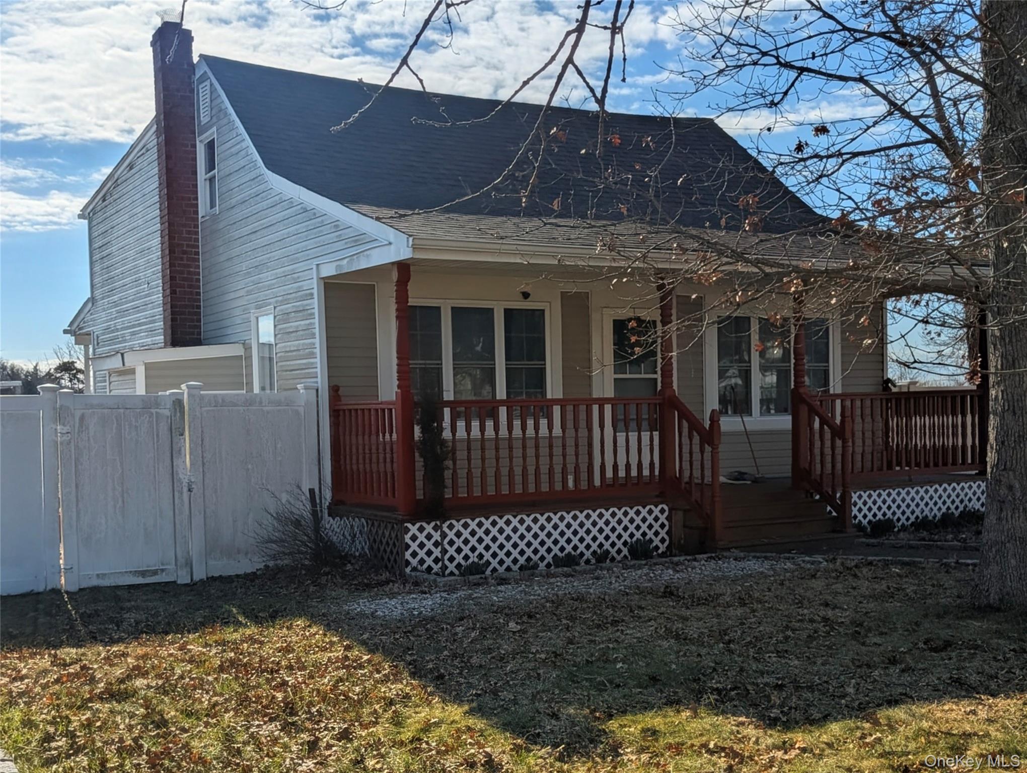 a view of a house with a small yard and wooden floor and fence