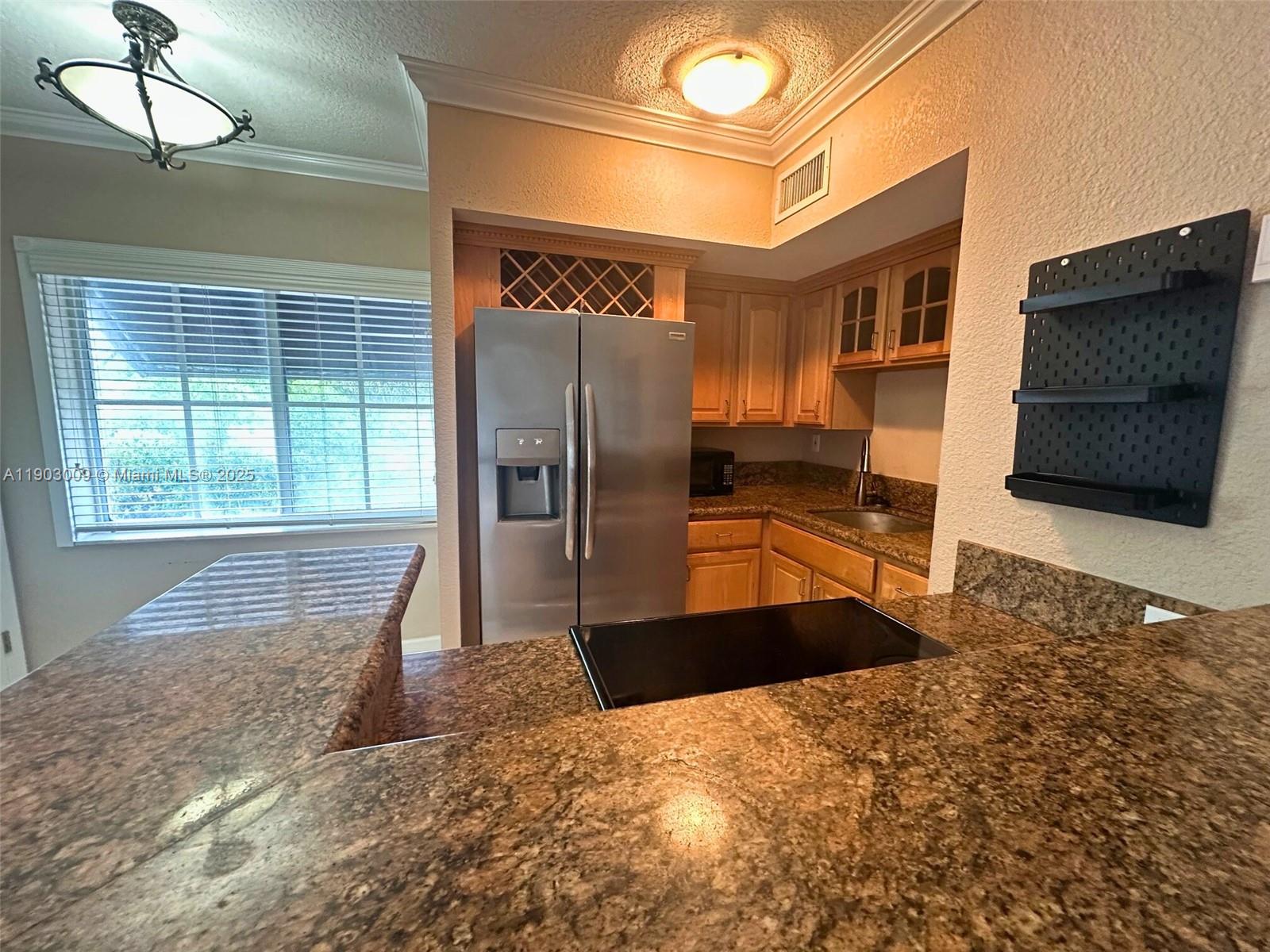924 Southeast 2nd Street, Unit 9 Fort Lauderdale, FL 33301 - Photo 7 of 19 a kitchen with stainless steel appliances kitchen island granite countertop a refrigerator and a sink