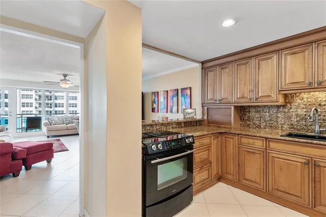 a kitchen with stainless steel appliances granite countertop a stove top oven a sink dishwasher and cabinets with wooden floor