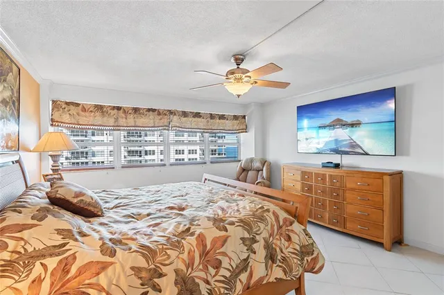 a bedroom with a large bed and a flat tv screen on dresser