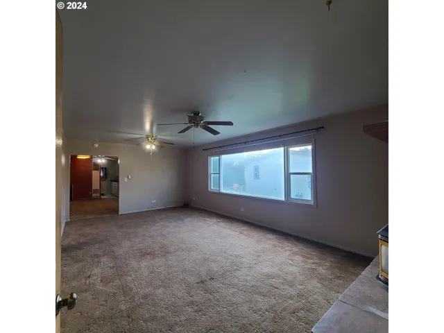 a view of a livingroom with a ceiling fan and window