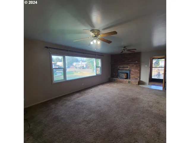a view of empty room with a ceiling fan and window