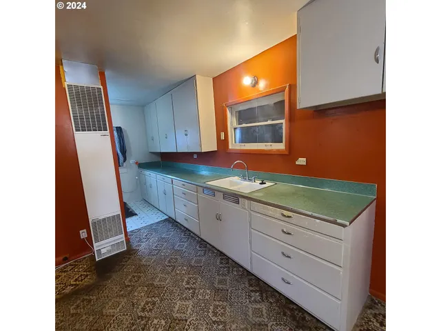 a kitchen with granite countertop a stove a sink and a microwave