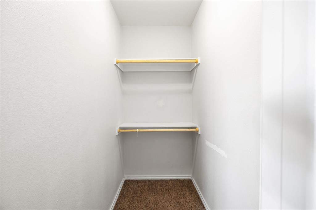9837 Walnut Street, Unit S203 Dallas, TX 75243 - Photo 16 of 26 This closet features two hanging rods with shelves, white walls, and carpeted flooring