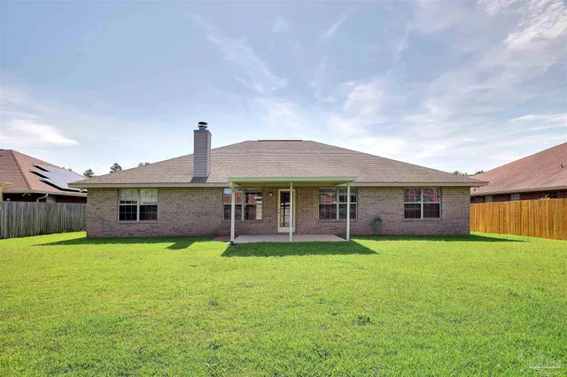 a view of a house with a yard and sitting area