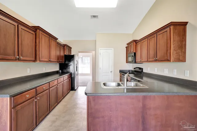 a kitchen with stainless steel appliances granite countertop a sink refrigerator and cabinets