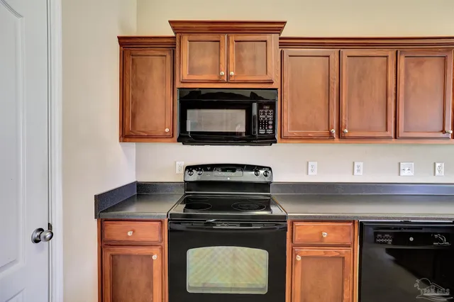 a kitchen with granite countertop a stove top oven microwave and cabinets