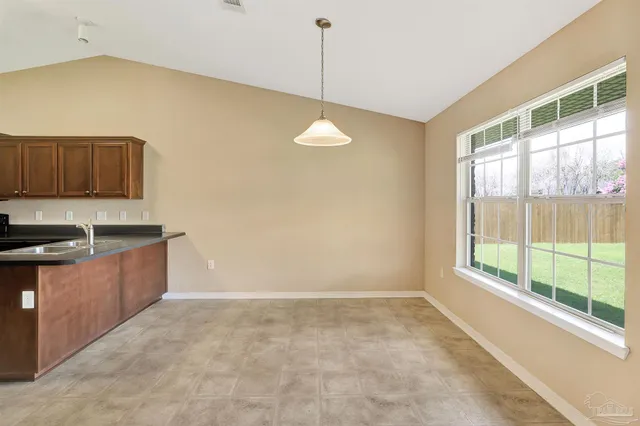 a kitchen with granite countertop a stove a sink and a refrigerator