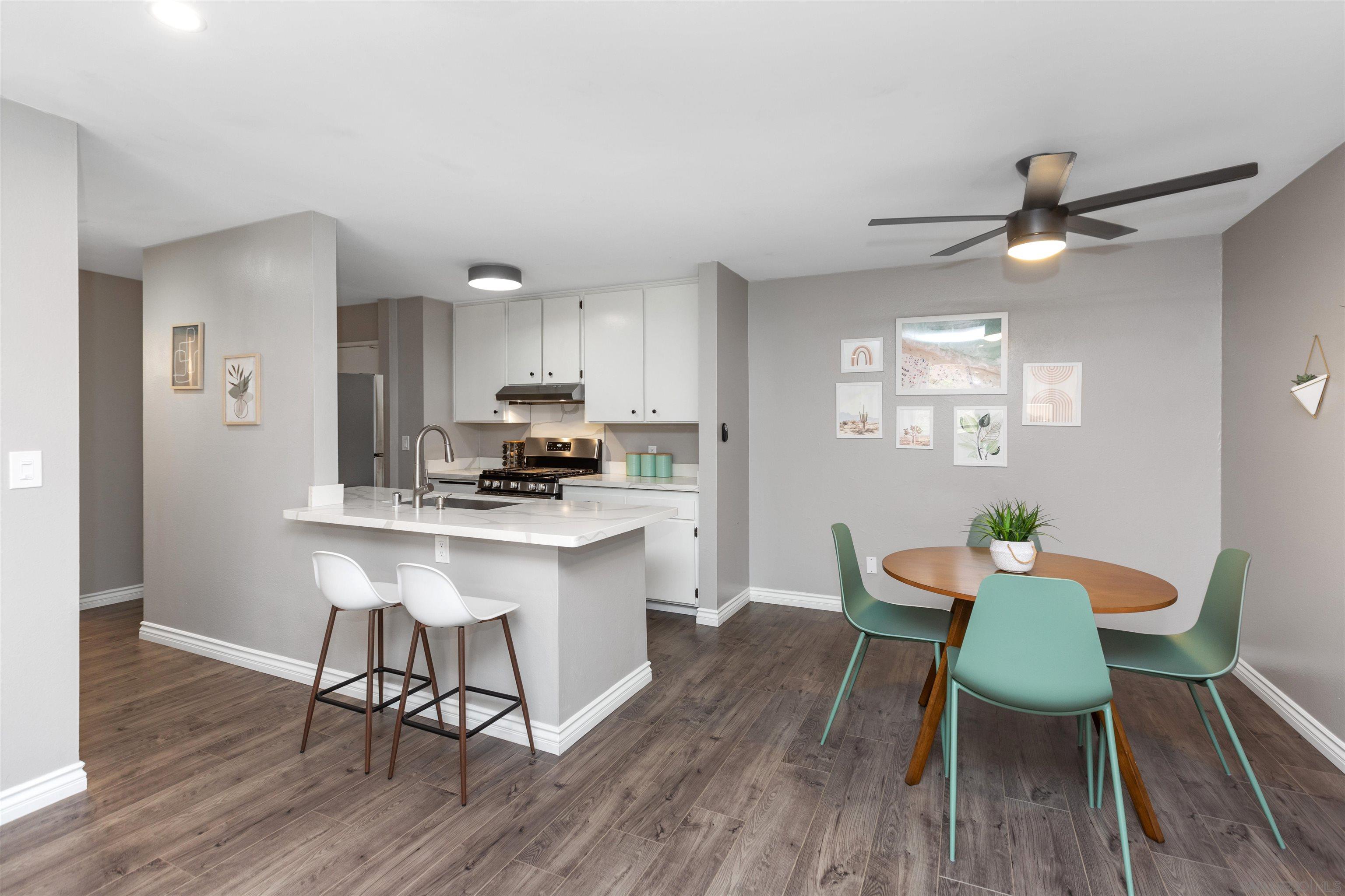 1621 Unit E 217, Unit E217 San Diego, CA 92108 - Photo 3 of 45 a kitchen with a dining table chairs and wooden floor