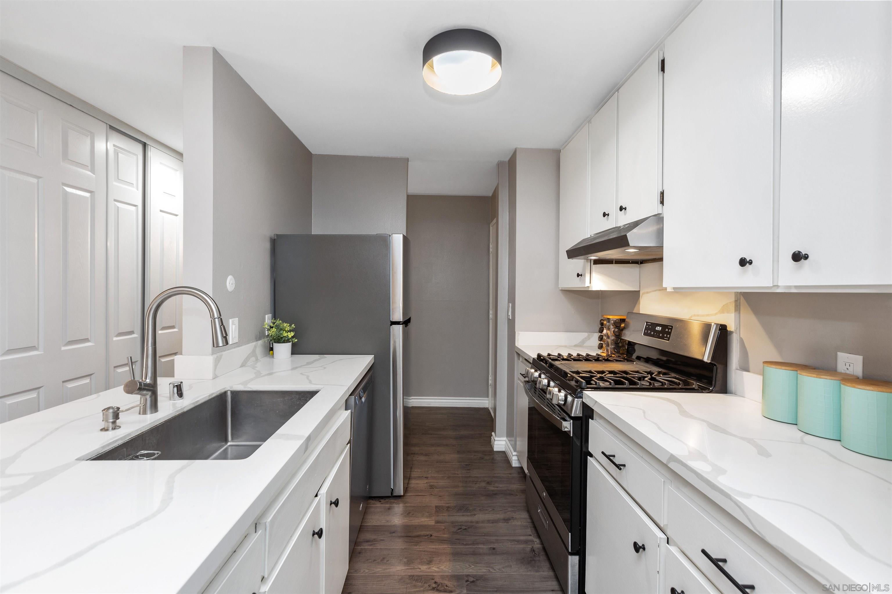 1621 Unit E 217, Unit E217 San Diego, CA 92108 - Photo 7 of 45 a kitchen with stainless steel appliances a sink stove and cabinets