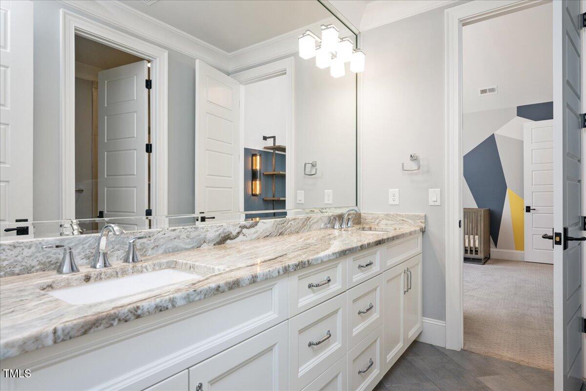 6502 New Market Way Raleigh, NC 27615 - Photo 36 of 54 a bathroom with a granite countertop double vanity sink and mirror