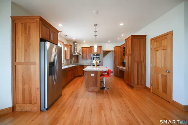a view of a kitchen with refrigerator and wooden floor