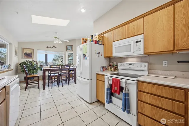 a kitchen with stainless steel appliances a stove a sink cabinets and a dining table
