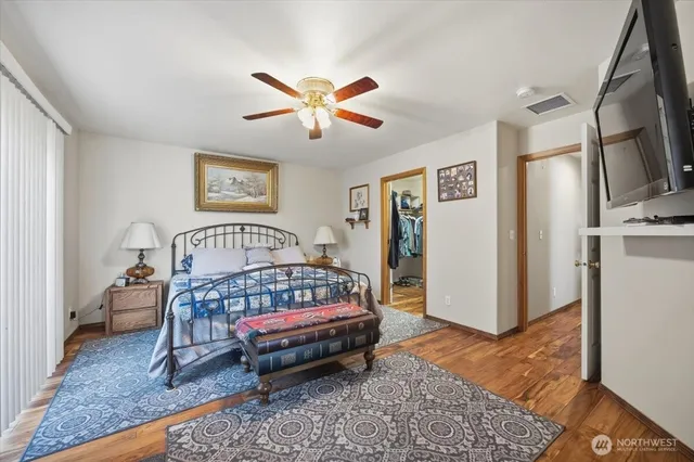 a bedroom with a bed a rug and wooden floor