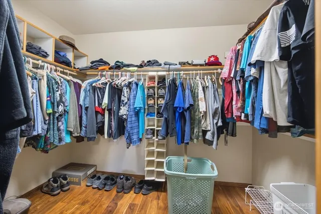 a view of walk in closet with clothes and shoes