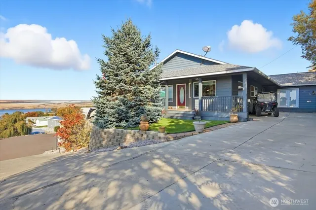 a front view of a house with a yard and potted plants