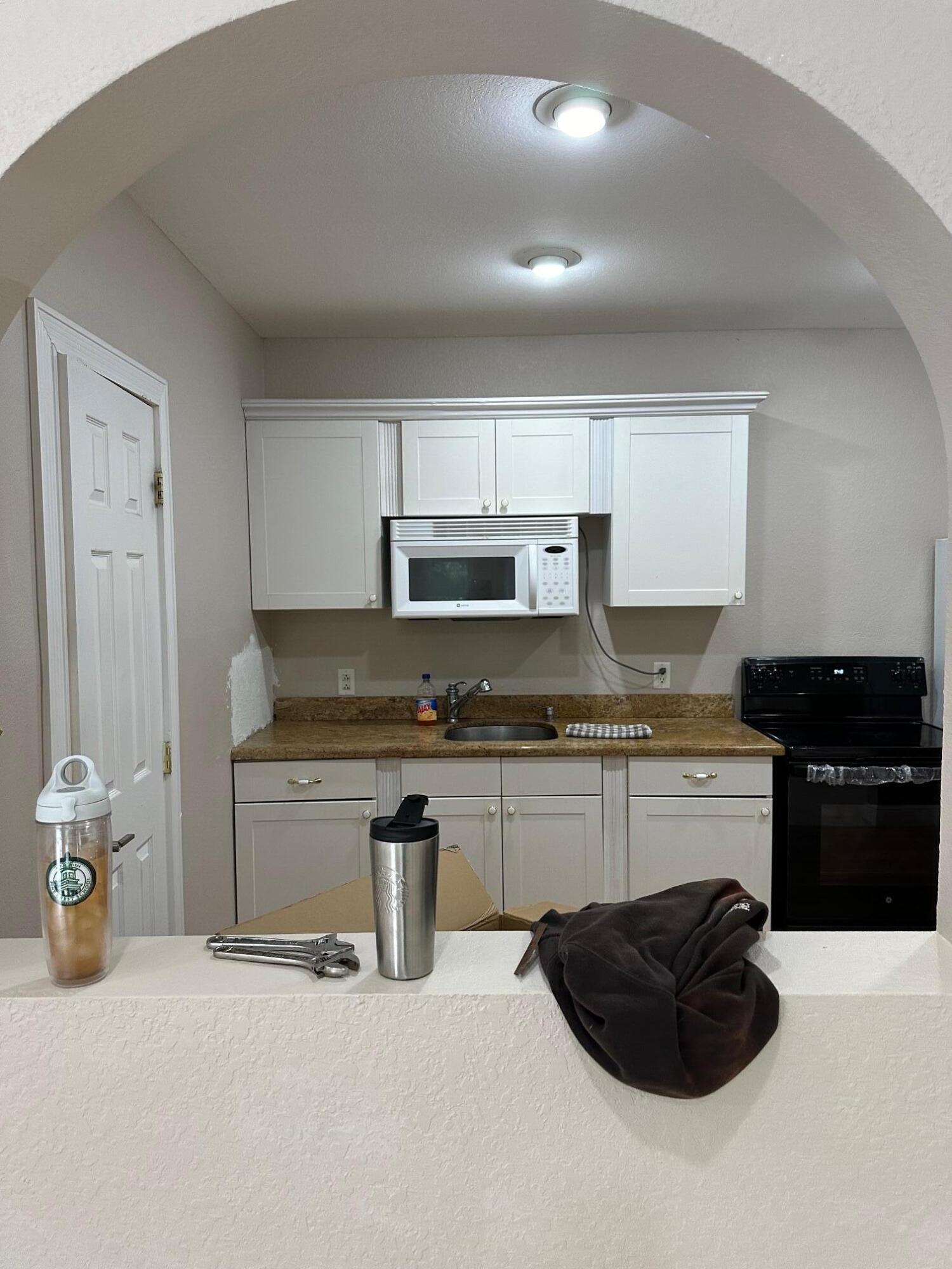 272 Southwest 1st Street, Unit B Boca Raton, FL 33432 - Photo 4 of 17 a kitchen with granite countertop a sink and a stove