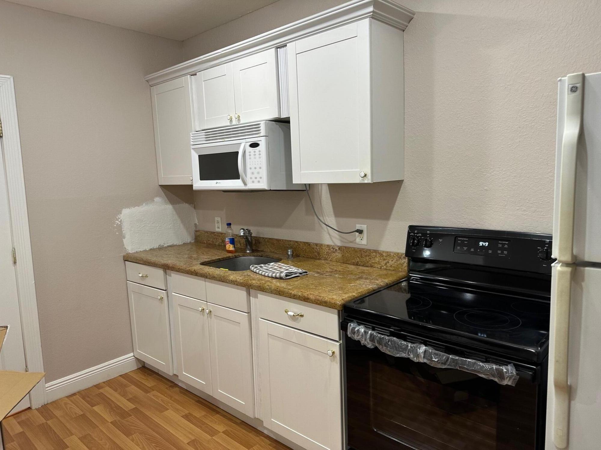 272 Southwest 1st Street, Unit B Boca Raton, FL 33432 - Photo 6 of 17 a kitchen with a stove and white cabinets