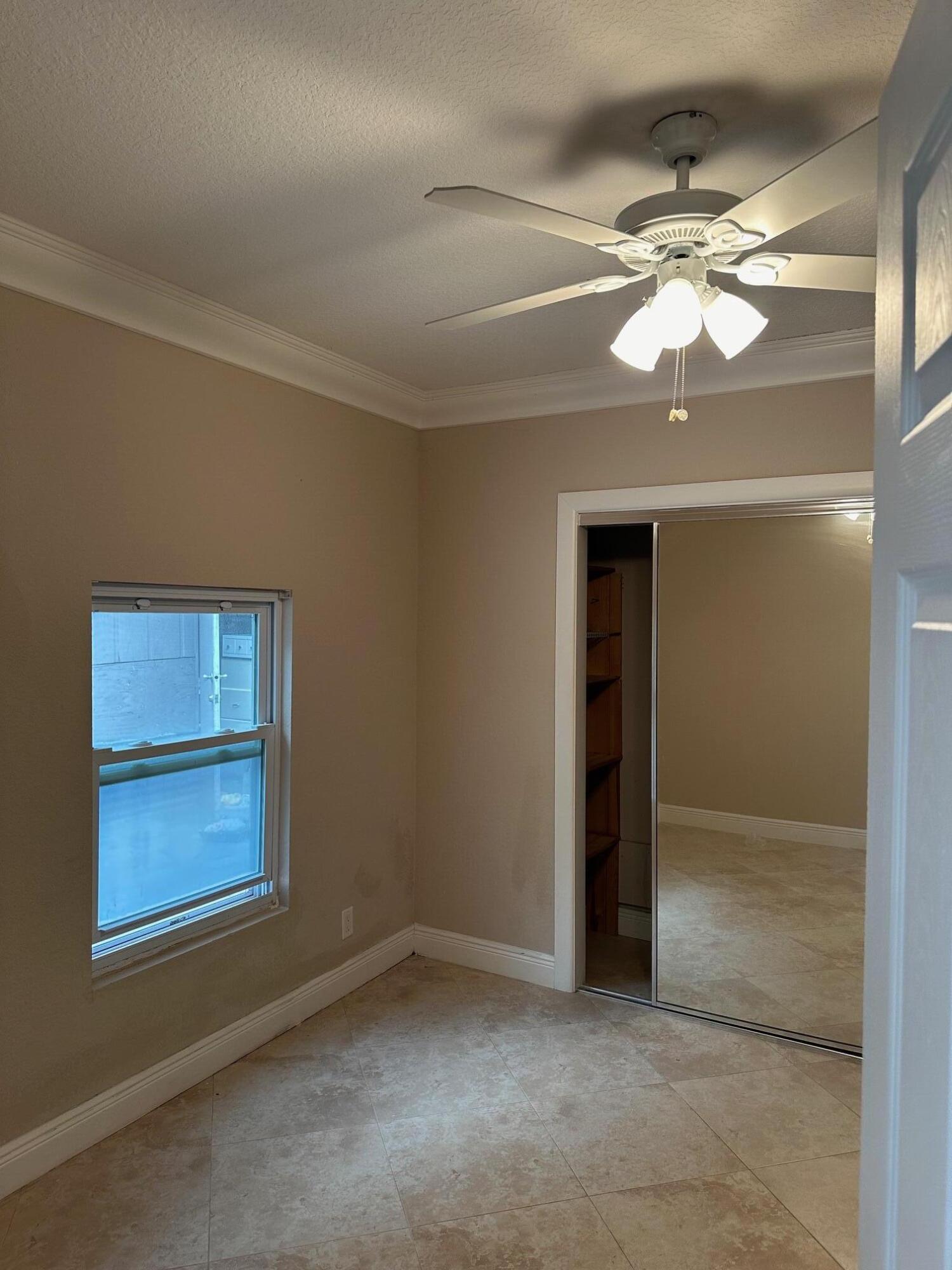 272 Southwest 1st Street, Unit B Boca Raton, FL 33432 - Photo 8 of 17 a view of an empty room with window and chandelier fan